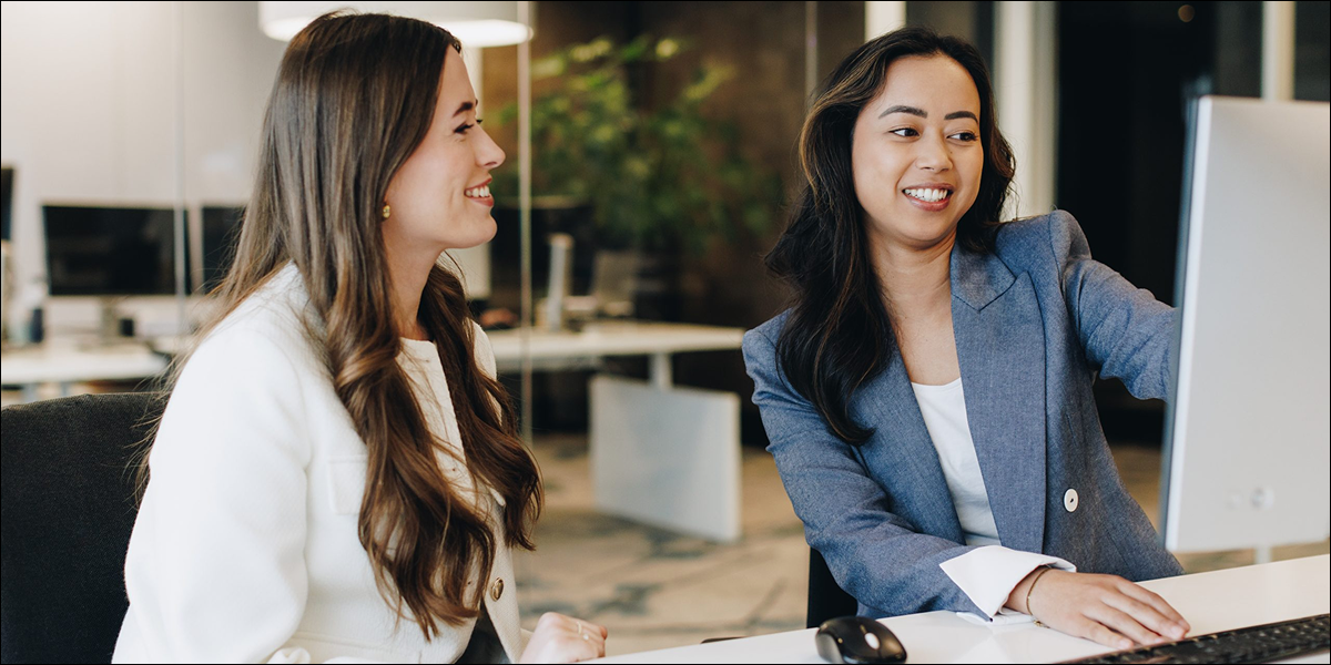 Two receptionists behind a computer